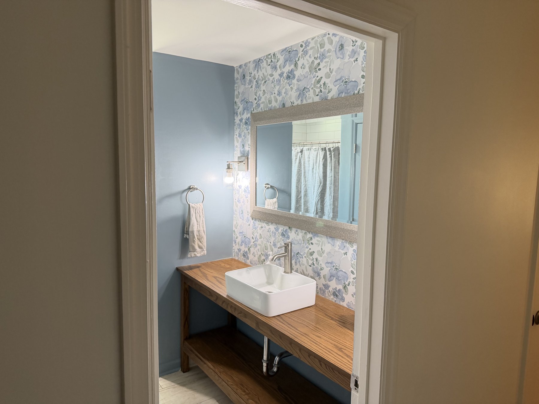 Powder room with floral wallpaper, custom oak vanity, and vessel sink